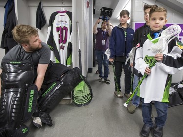 Nine-year-old Cohyn Wells enters the locker room and is greeted by Rush goalie Tyler Carlson, following Wells' signing of a one-day contract with the Saskatchewan Rush, March 26, 2016. Wells is the Saskatchewan representative for the Children's Miracle Network's Champion Program.