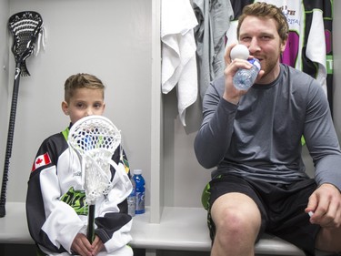 Nine-year-old Cohyn Wells enters the locker room and is greeted by Rush forward Ben Mcintosh, following Wells signing of a one-day contract with the Saskatchewan Rush, March 26, 2016. Wells is the Saskatchewan representative for the Children's Miracle Network's Champion Program.