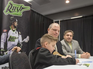 Saskatchewan Rush captain Chris Corbeil (not shown), nine-year-old Cohyn Wells (L) and Rush head coach and general manager Derek Keenan (C) hold a press conference for the signing of a one-day contract of Cohyn to the Saskatchewan Rush, March 26, 2016. Wells is the Saskatchewan representative for the Children's Miracle Network's Champion Program.