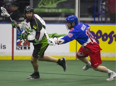 Saskatchewan Rush defence Kyle Rubisch moves the ball away from Toronto Rock forward Rob Hellyer in NLL action, March 26, 2016.