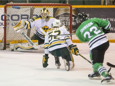 University of Saskatchewan Huskies forward Andrew Johnson's shot goes off the post while University of Alberta Golden Bears goalie Luke Siemens looks on during first period CIS Men's Hockey action on March 5, 2016.