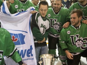 University of Saskatchewan Huskies forward Kohl Bauml brings his brother on to the ice to celebrate after defeating the University of Alberta Golden Bears to win the CIS Men's Hockey Canada West championship on March 5, 2016.