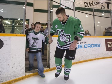 University of Saskatchewan Huskies forward Kohl Bauml brings his brother on to the ice to celebrate after defeating the University of Alberta Golden Bears to win the CIS Men's Hockey Canada West championship on March 5, 2016.