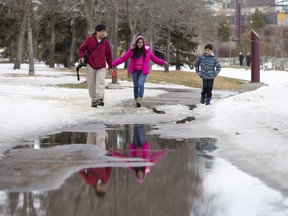 L-R: Ador Manahan, his 13-year-old daughter Jedidiah and nine-year-old son Jaod walk along the Meewasin Trail near Victoria Park in Saskatoon, March 6, 2016.