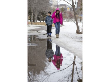 Thirteen-year-old Jedidiah Manahan (R) and her nine-year-old brother Jaod walk along the Meewasin Trail near Victoria Park in Saskatoon, March 6, 2016.