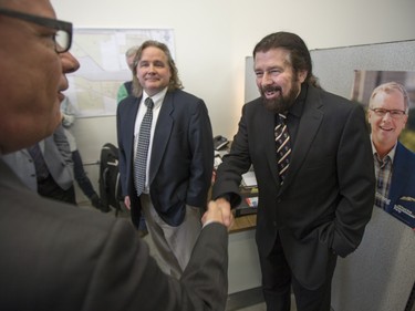 Mark Brayford (R) shakes hands with Saskatchewan Premier Brad Wall, as he speaks to campaign volunteers and media at the Saskatoon Stonebridge-Dakota Campaign Office on March 7, 2016.