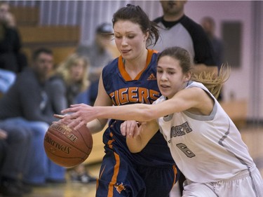 Tommy Douglas Tigers' Tori Hanson has a difficult time cutting in to the basket with St. Joseph Guardians #6 Sarah Hazen playing tight defence during a Saskatoon High School basketball playoff  game, March 9, 2016.