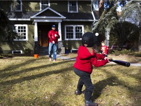 Greg McDonald (L) plays baseball with his sons George (C) and Joe (R) at home during a  sunny afternoon in Saskatoon, March 13, 2016.