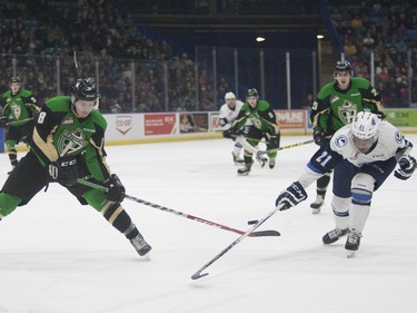 Saskatoon Blades #21 Lukus MacKenzie (R) fights for the puck against Prince Albert Raiders #8 Cody Paivarinta (L) during Saturday night's game at SaskTel Centre in Saskatoon where the Blades took home a 3-2 victory over the Raiders, March 19, 2016.
