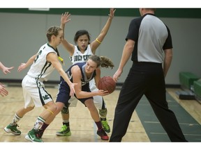 File Photo. -- Katriana Philipenko and teammate Jessie De Castro of Holy Cross, defend against Kate Thorstad of Walter Murray in high school basketball action at Holy Cross, Tuesday, March 01, 2016. (GREG PENDER/ SASKATOON STARPHOENIX)