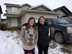Tina Jackson (right) and her daughter Rebecca in front of the Westview home they've been trying unsuccessfully to sell.