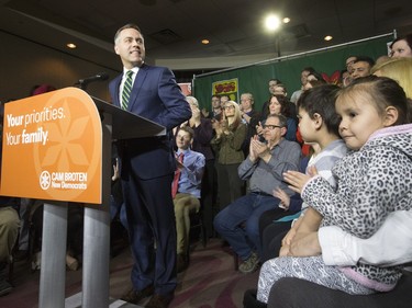 NDP leader Cam Broten speaks during a news conference at TCU Place as five-year-old twins Connor and Devon Hicks (R) listen, March 17, 2016.