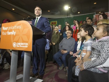 NDP leader Cam Broten speaks during a news conference at TCU Place as five-year-old twins Connor and Devon Hicks (R) listen, March 17, 2016.