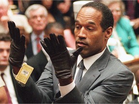 FILE - In this Wednesday, June 21, 1995 file photo, O.J. Simpson holds up his hands before the jury after putting on a new pair of gloves similar to the infamous bloody gloves during his double-murder trial in Los Angeles.