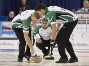Team Saskatchewan skip Steve Laycock looks down ice as second Colton Flasch and lead Dallan Muyres sweep during round robin competition against Team Newfoundland and Labrador at the Brier curling championship Monday, March 7, 2016 in Ottawa.
