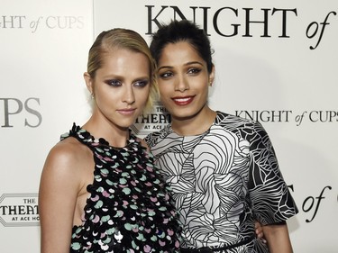 Teresa Palmer (L) and Freida Pinto arrive at the premiere of "Knight of Cups" at The Theatre at Ace Hotel, in Los Angeles, California, March 1, 2016.