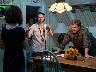 Director Dan Trachtenberg (C) talks with actors John Goodman and Mary Elizabeth Winstead on the set of "10 Cloverfield Lane."