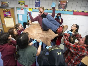 Students from the Thunderchild First Nation's Miyo Pimatsowin program toss teacher associate Susy Lister in the air with a deer hide they have stretched.