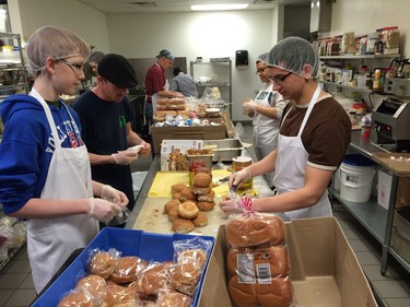 Volunteers and staff work Saturday to compile lunches after a water main break at the Friendship Inn.