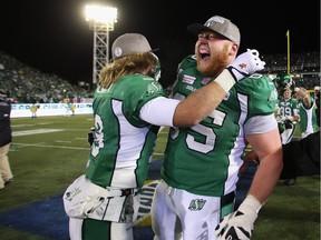 Ex-Huskies Scott McHenry (left) and Ben Heenan celebrate the Saskatchewan Roughriders' 45-23 victory over the Hamilton Tiger-Cats during the 2013 Grey Cup.