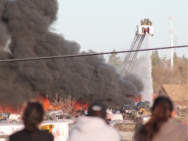 A crowd gathered to watch firefighters battle a blaze at an auto salvage yard at Avenue P and 14th Street West in Saskatoon on April 19, 2016.