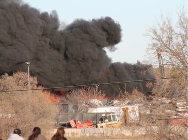 A crowd gathered to watch firefighters battle a blaze at an auto salvage yard at Avenue P and 14th Street West in Saskatoon on April 19, 2016.