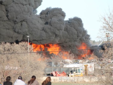 A crowd gathered to watch firefighters battle a blaze at an auto salvage yard at Avenue P and 14th Street West in Saskatoon on April 19, 2016.