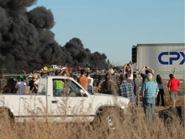 A crowd gathered to watch firefighters battle a blaze at an auto salvage yard at Avenue P and 14th Street West in Saskatoon on April 19, 2016.