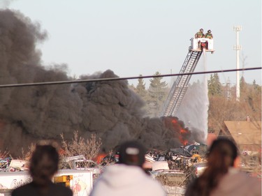 A crowd gathered to watch firefighters battle a blaze at an auto salvage yard at Avenue P and 14th Street West in Saskatoon on April 19, 2016.