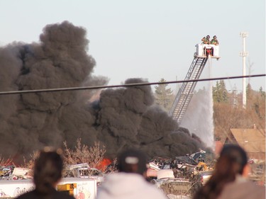 A crowd gathered to watch firefighters battle a blaze at an auto salvage yard at Avenue P and 14th Street West in Saskatoon on April 19, 2016.