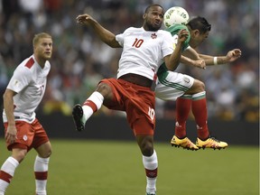 Canada's Junior Hoilett (C) jumps for a header with a Mexican player during their Russia 2018 FIFA World Cup Concacaf Qualifiers' football match, in Mexico City, on March 29, 2016.