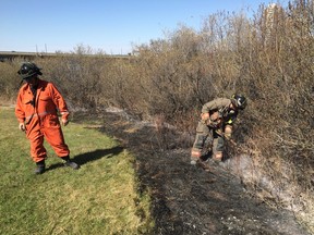 Firefighters worked to put out what remained of a grass fire on the east riverbank between the Broadway and University Bridges in Saskatoon.