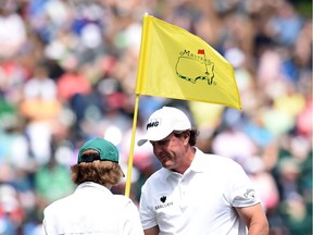 US golfer Phil Mickelson talks to his son Evan during the Par 3 contest prior to the start of the 80th Masters of Tournament at the Augusta National Golf Club on April 6, 2016, in Augusta, Georgia. /