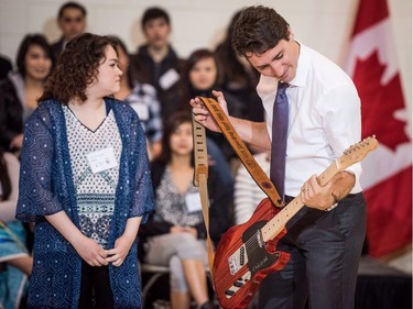 Kristin Albert presents Prime Minister Justin Trudeau with a guitar built by students as a gift during his visit at Oskayak High School in Saskatoon, April 27, 2016.