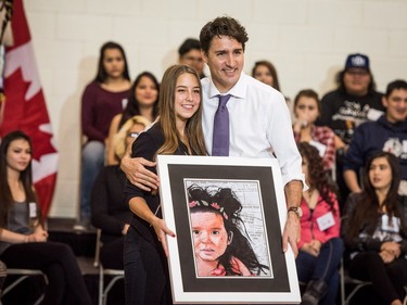 Prime Minister Justin Trudeau is given a painting by Metis artist Jasmine Sites as a gift during his visit at Oskayak High School in Saskatoon, April 27, 2016.
