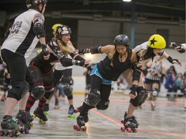 Team White takes on Team Black in a Invitational Scrimmage at the home opener for the Saskatoon Roller Derby League at Archibald Arena, April 2, 2016.