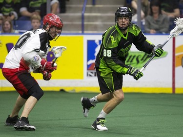 Saskatchewan Rush forward Zack Greer moves the ball against Calgary Roughnecks transition Curtis Manning in NLL action on April 2, 2016