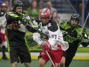 Saskatchewan Rush defenders Chris Corbeil (left) and Kyle Rubisch put pressure on Calgary Roughnecks forward Jeff Shattler before a sellout crowd Saturday night.