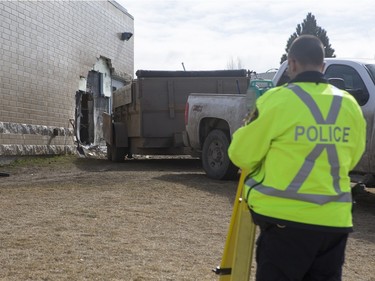 The Saskatoon Police Collision Analyst Unit and workers on the scene of Silverspring School on Sunday, April 3, 2016. Earlier in the morning a 25 year driver went over an embankment and collided with the school.