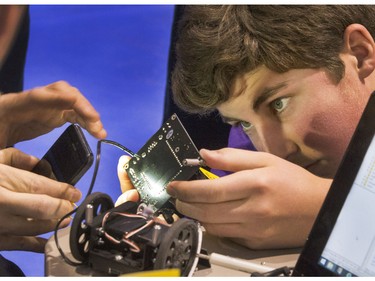 Reid Madsen from Walter W. Brown School in Langham  gets help with a iPhone light to do some work on his robot preparing for the8th annual Polytechnic Sumobot Robot Rumble,  April 14, 2016.
