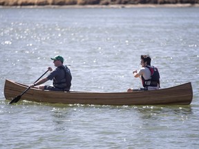 Holy Cross high school student Matt Ehrlich, right, and his shop teacher Ron Blais, ride Ehrlich's cedar strip canoe, that he built in shop class, in to the river on it's madden voyage at Gabriel Dumont Park on Sunday, April 17th, 2016. (Liam Richards/Saskatoon StarPhoenix)