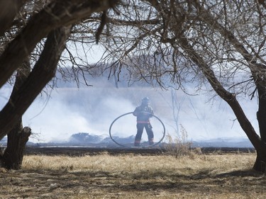 Saskatoon and Warmen firefighters battle a grass fire on an acreage north of Cathedral Bluffs on April 17, 2016.