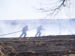 Saskatoon and Warman firefighters battle a grass fire on an acreage north of Cathedral Bluffs on April 17, 2016.
