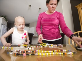 Seven-year-old Naomi Lendvay, who is battling stage four cancer (Rhabdomyosarcoma), shows off her Beads of Courage necklaces alongside her mother, Vanessa. The beads are collected based on treatments and events during a child's battle with cancer. April 18, 2016.