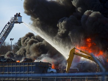 An auto wrecking yard at Avenue P South and 14th Street West was burning intensely for firefighters who battled it with their ladder truck, April 19, 2016.