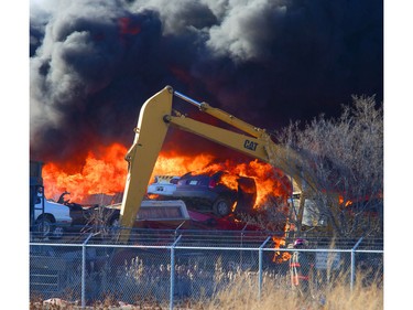 An auto wrecking yard at Avenue P South and 14th Street West was burning intensely for firefighters who battled it with their ladder truck, April 19, 2016.