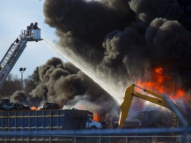 An auto wrecking yard at Avenue P South and 14th Street West was burning intensely for firefighters who battled it with their ladder truck, April 19, 2016.