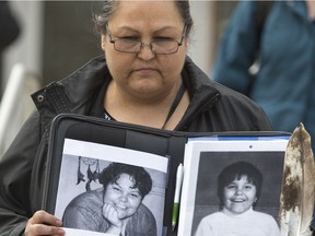 Kinew James's sister Cheryl James holds photos of Kinew outside Saskatoon Court of Queen's Bench on Monday. An inquest into Kinew James's death at the Regional Psychiatric Centre was scheduled to begin Monday but was adjourned after the family made a request for the scope of the inquest to be expanded.