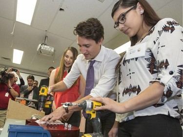 Prime Minister Justin Trudeau was at Oskayak High School in the Aboringinal Youth Entrepreneurship Program where he enjoyed helping Johannah Angus and Kayla Verbonac put together parts of a guitar that was later given to him as a gift, April 27, 2016. The back of the guitar was signed by the students in the class.