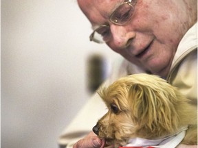 Veteran Don Barrett gets Kendi to lick his finger while spending time with this therapy dog at a University of Saskatchewan conference that highlighted research on the health effects of therapy dogs on elderly veterans.